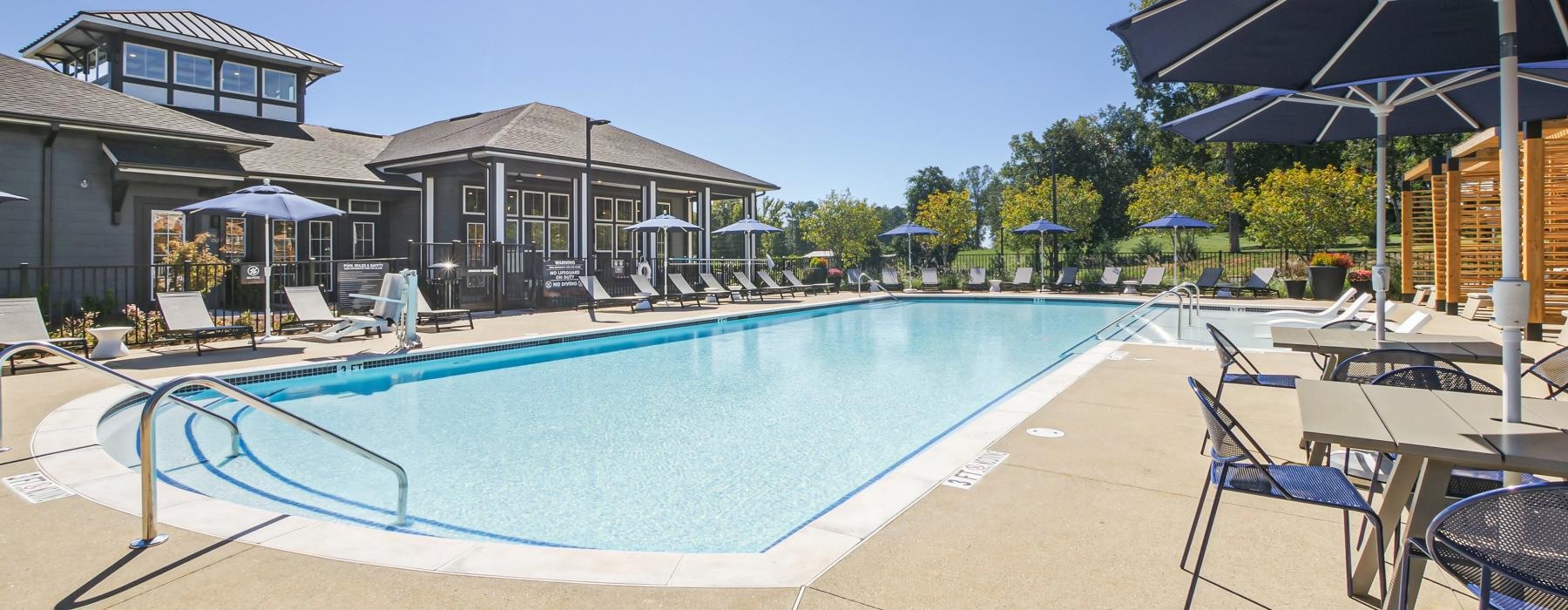 umbrella shaded tables and chairs next to pool